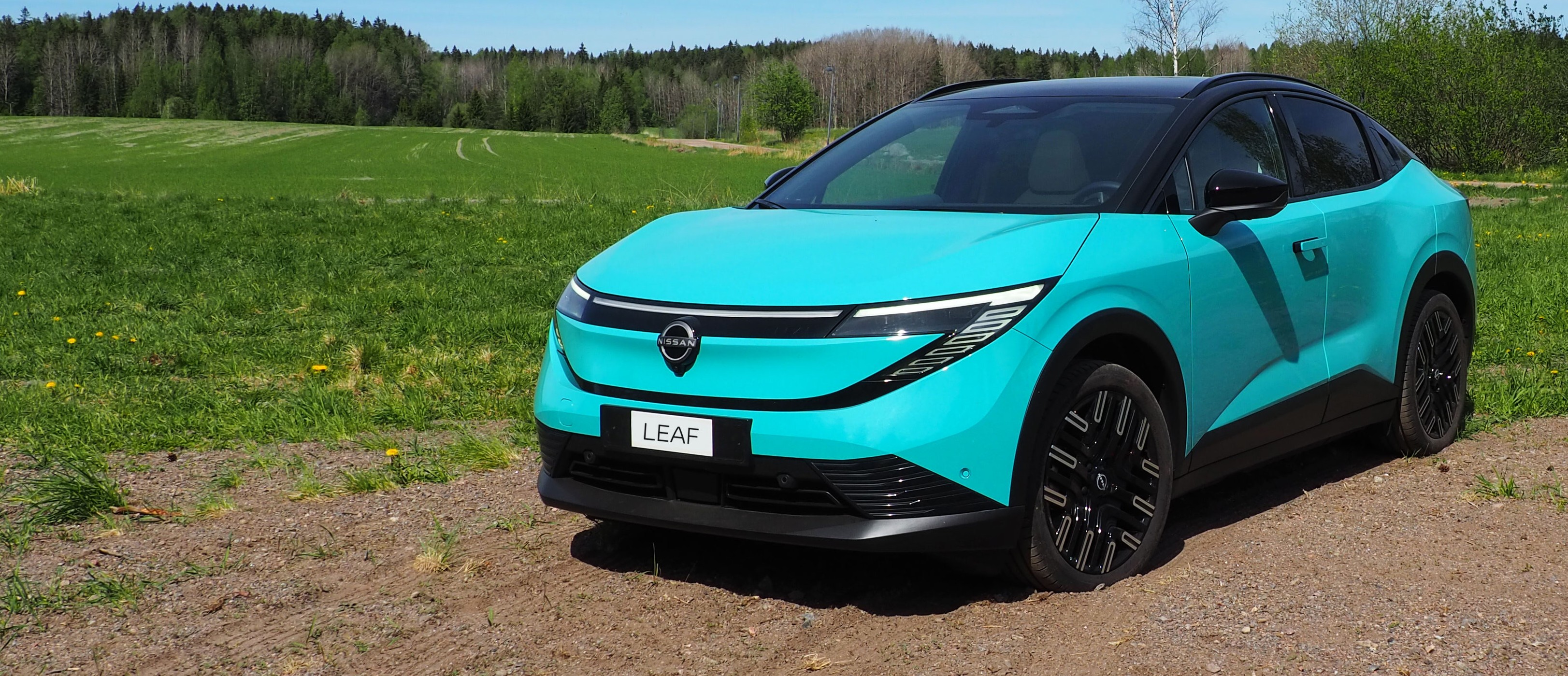 Täysin uusi Nissan LEAF viheralueen edessä