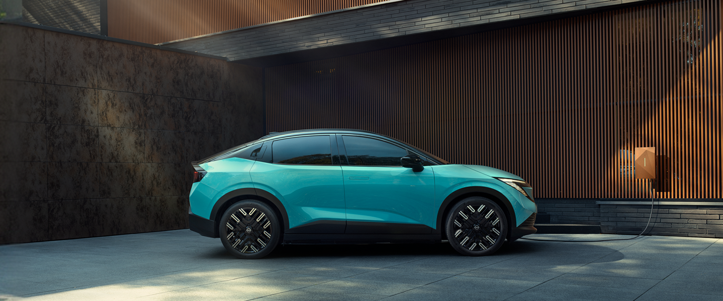 En Nissan ARIYA LEAF og MICRA placeret ved siden af hinanden på en blå baggrund
