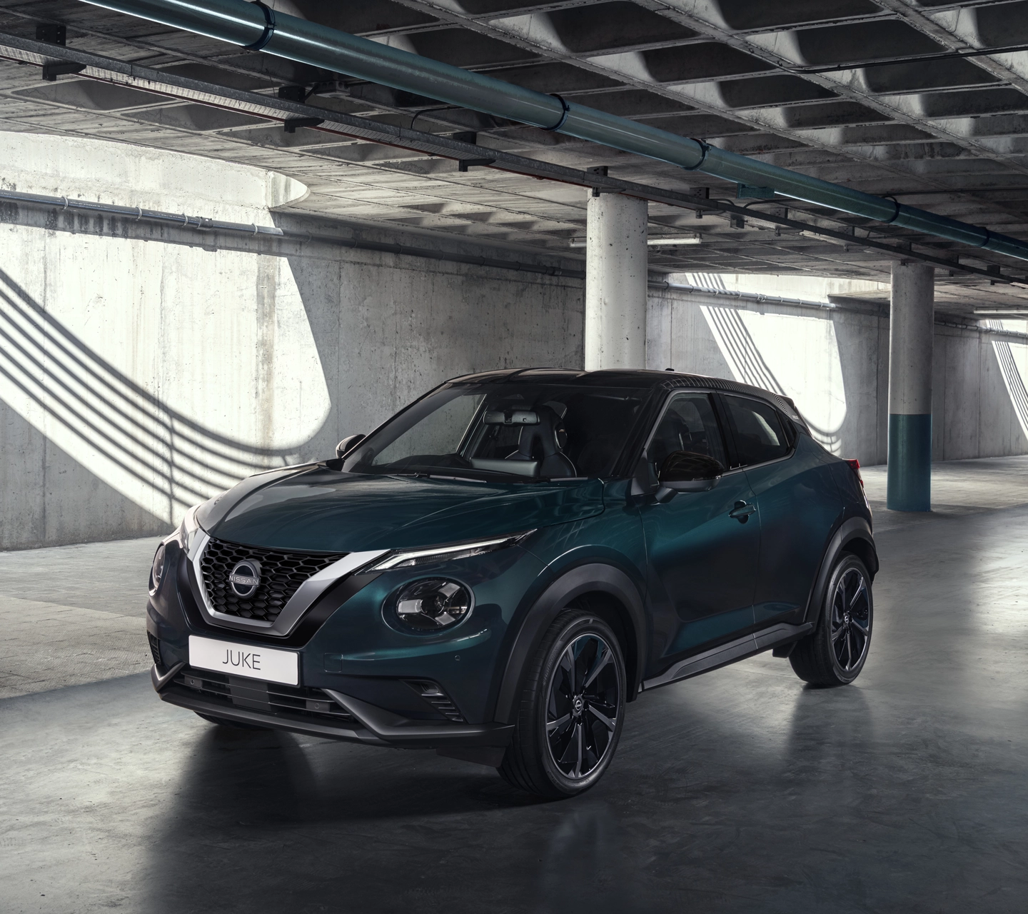 Nissan Juke profile view parked next to shop with person standing outside holding phone