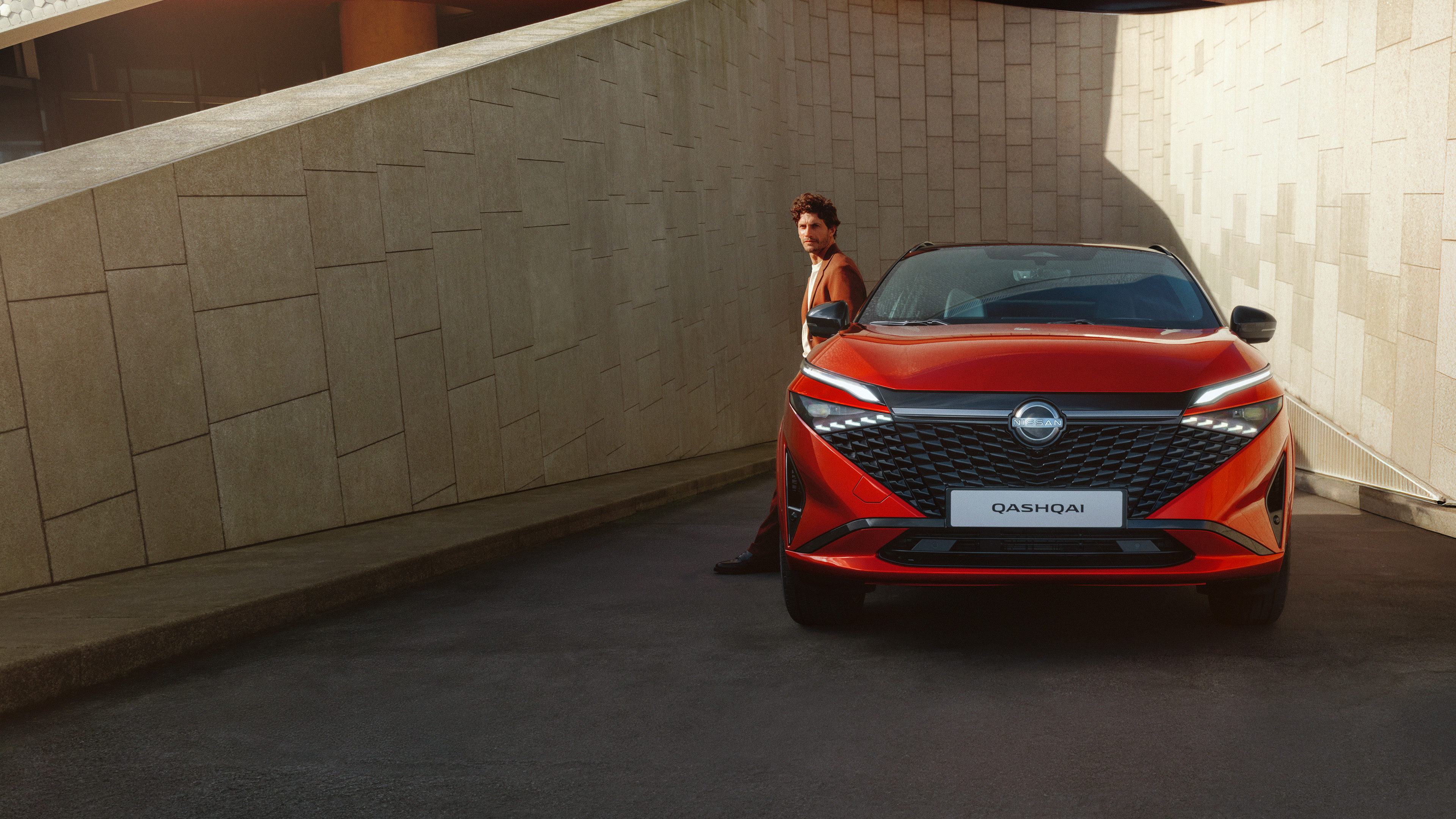 Nissan Qashqai e-Power full front static view with man leaning against the bonnet.