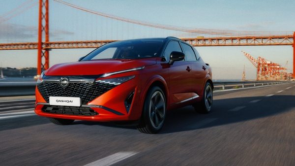 Red qashqai driving on a road under golden gate bridge