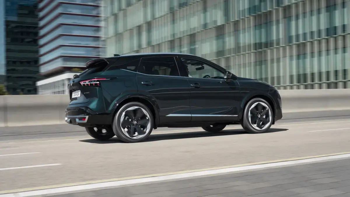 nissan qashqai driving on a road, london buildings in the background
