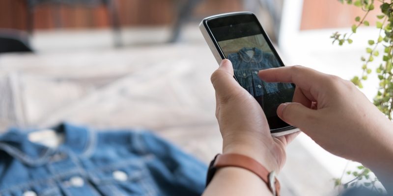 Woman taking picture of jacket with phone