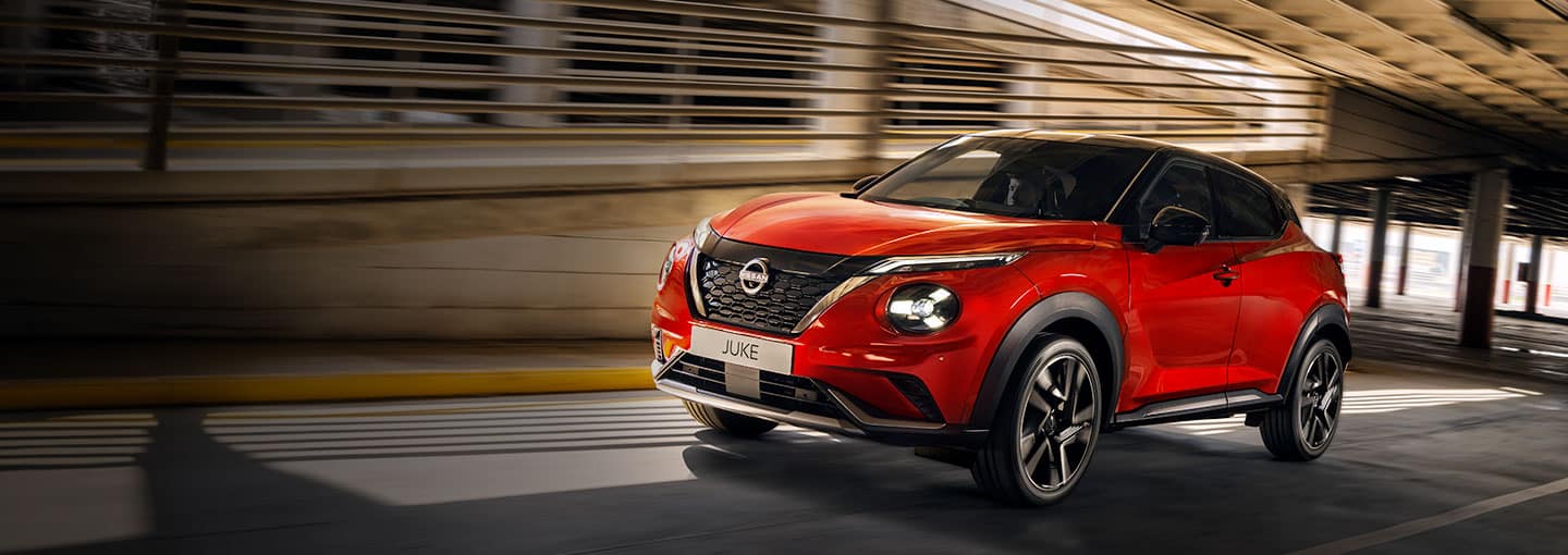 Nissan Juke vue statique 3/4 face devant un entrepôt