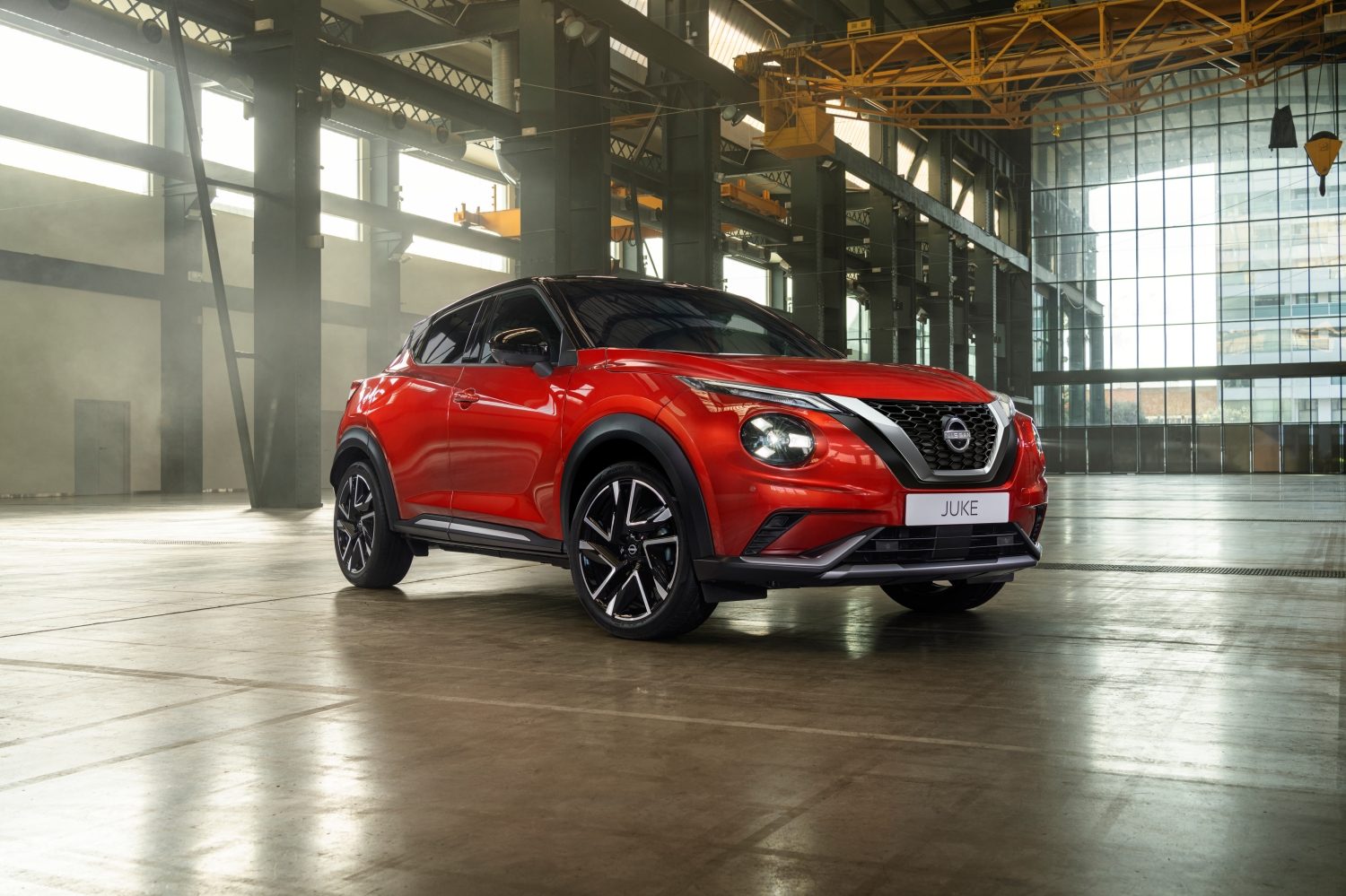 Nissan Juke vue de face devant un magasin, avec une personne tenant un téléphone
