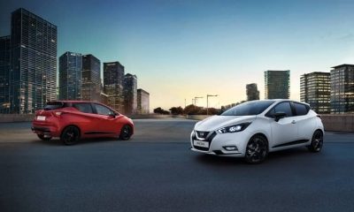 שתי מכוניות ניסאן מיקרה לבנה ואדומה על רקע נוף עירוני.