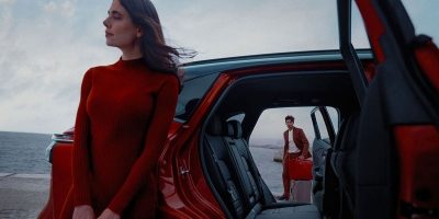 אישה וגבר עומדים לצד רכב ניסאן קשקאי על חוף הים