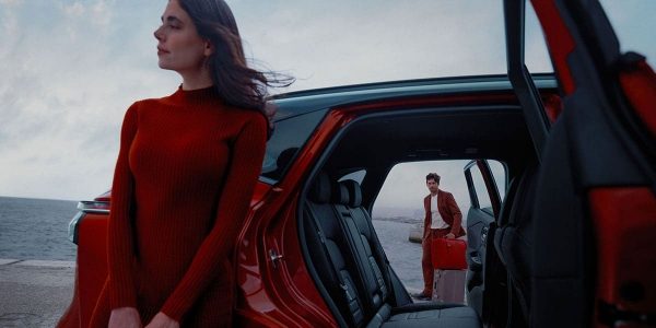 אישה וגבר עומדים לצד רכב ניסאן קשקאי על חוף הים