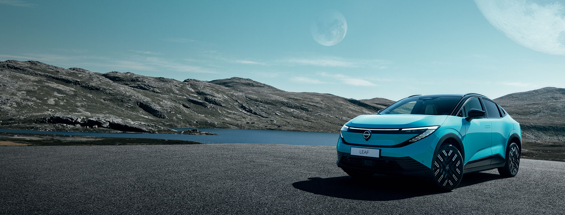 Nissan LEAF 100% elettrica con lago e montagne sullo sfondo