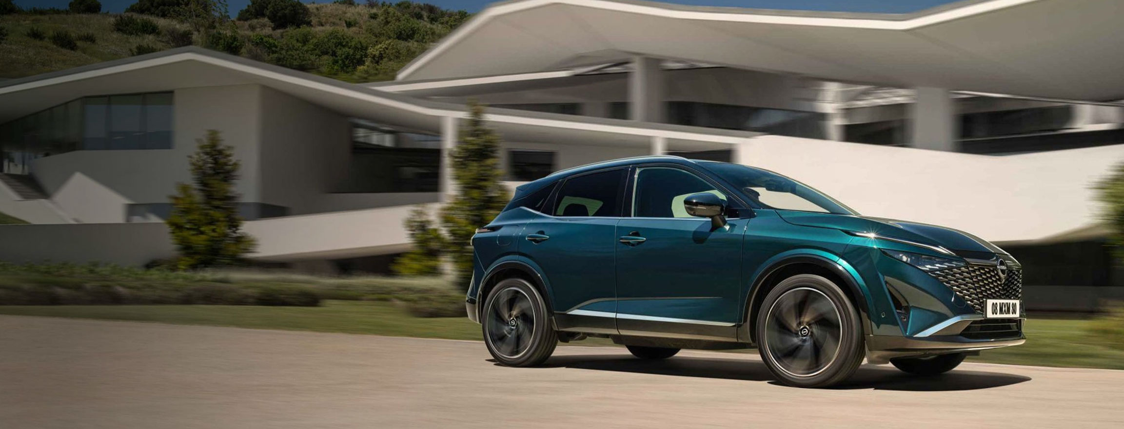 Nissan Qashqai e-Power in marcia davanti ad alcune case