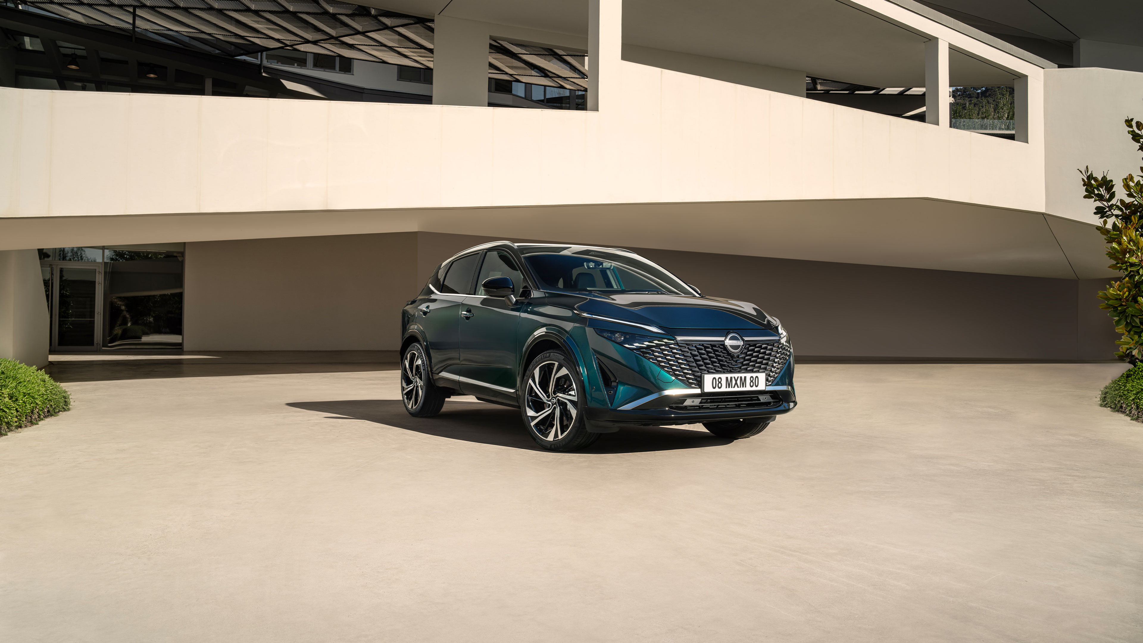 Immagine frontale statica di Nissan QASHQAI e-POWER con un uomo che si sporge sopra il cofano.