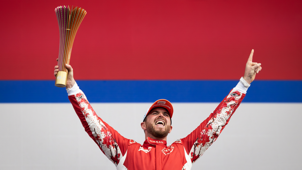 Oliver Rowland celebrating his victory, holding up the trophy.
