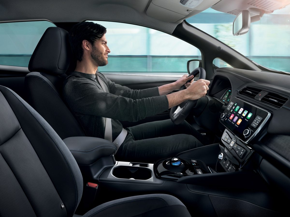 Vue intérieure de profil d’un homme conduisant une Nissan LEAF