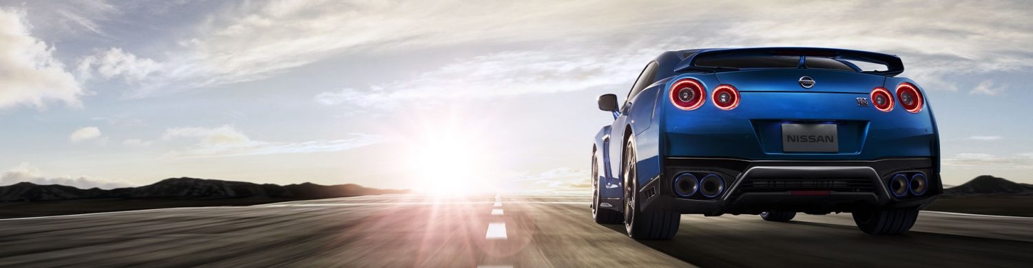A view on the back of blue Nisan GT-R driving on the open road.