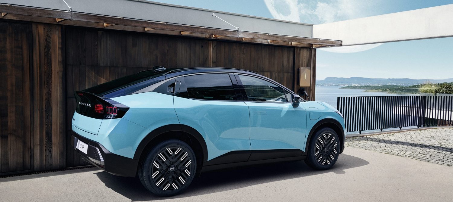 Nissan Ariya sett fra venstre i 3/4 front, parkert og lader.