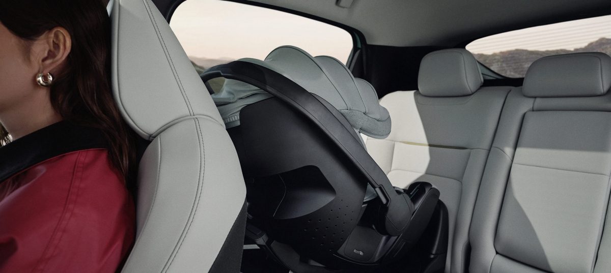 Atgal nusukta kūdikio kėdutė, sumontuota ant galinės „Nissan LEAF“ sėdynės.