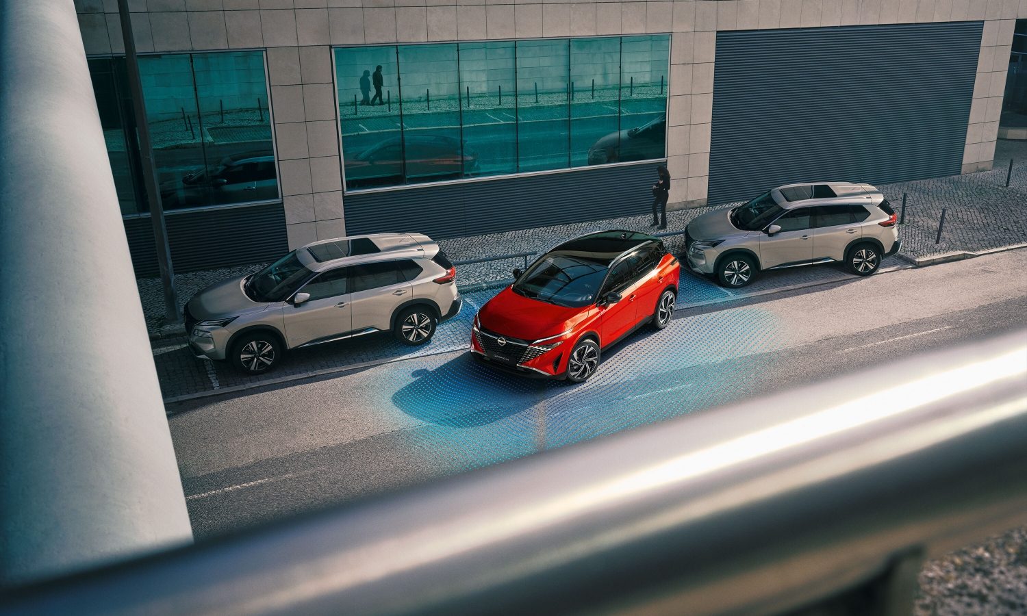 Nissan Qashqai e-Power 3/4 front static shot in front of building with woman walking towards car - Hybrid SUV
