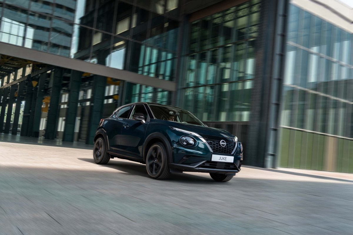 3/4 Vy framifrån av Nissan JUKE parkerad framför vägg med gula ballonger