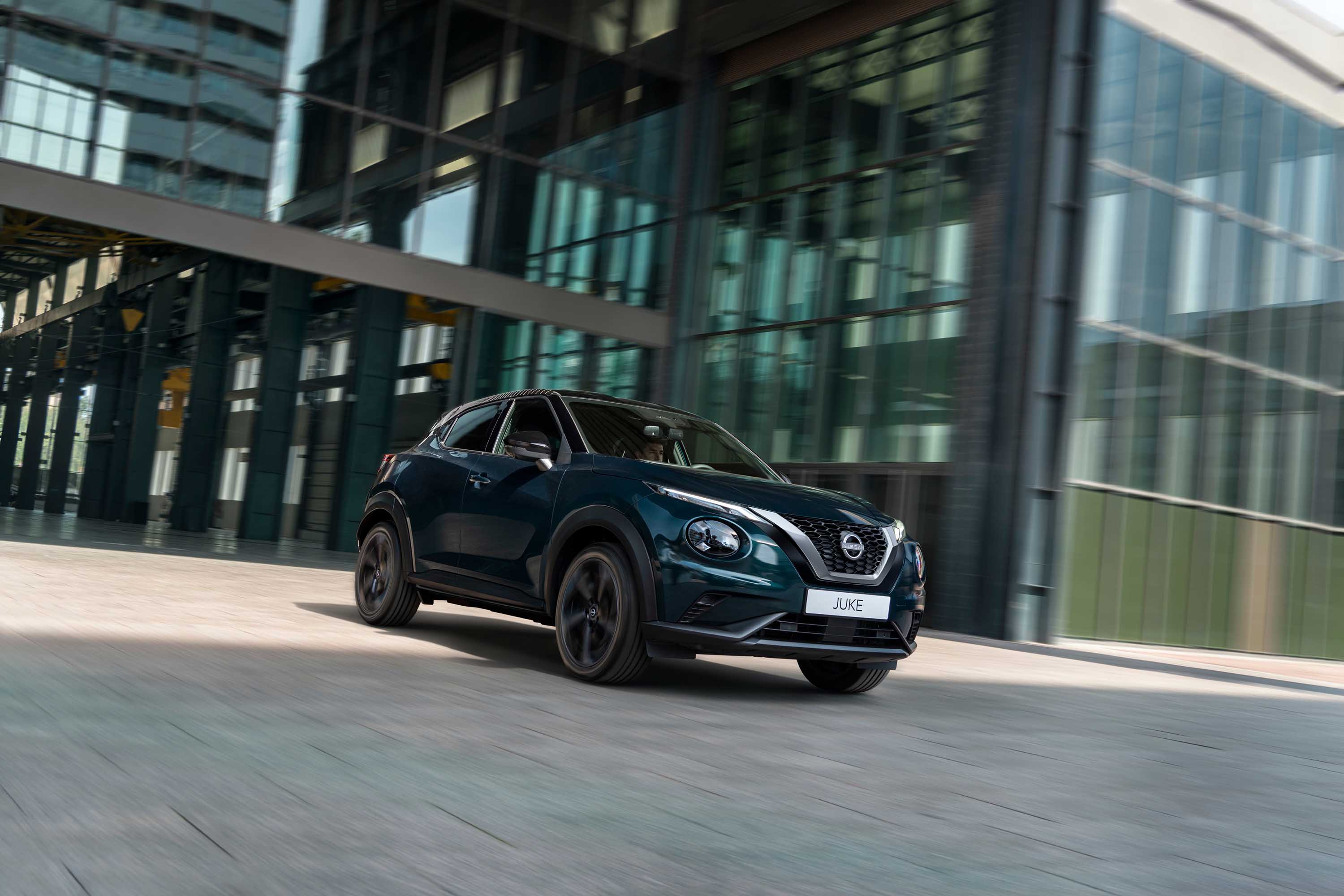 3/4 vy bakifrån av Nissan JUKE Hybrid SUV med bröllopspar som går iväg