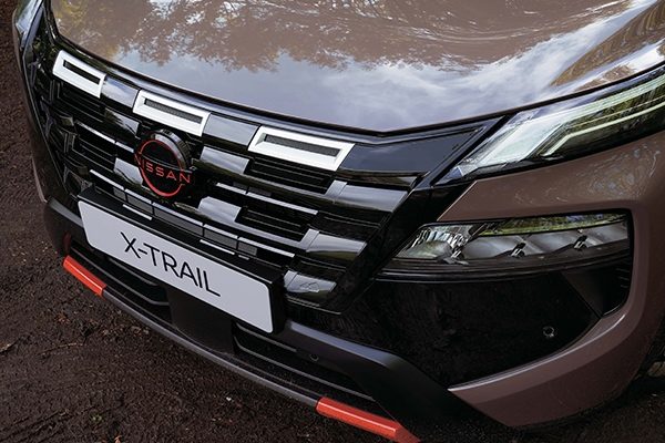 Nissan X-Trail dark motion grille front view with kids