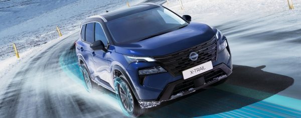 Nissan X-Trail, plavo vozilo, bočni pogled u vožnji po snijegu s efektima pogona