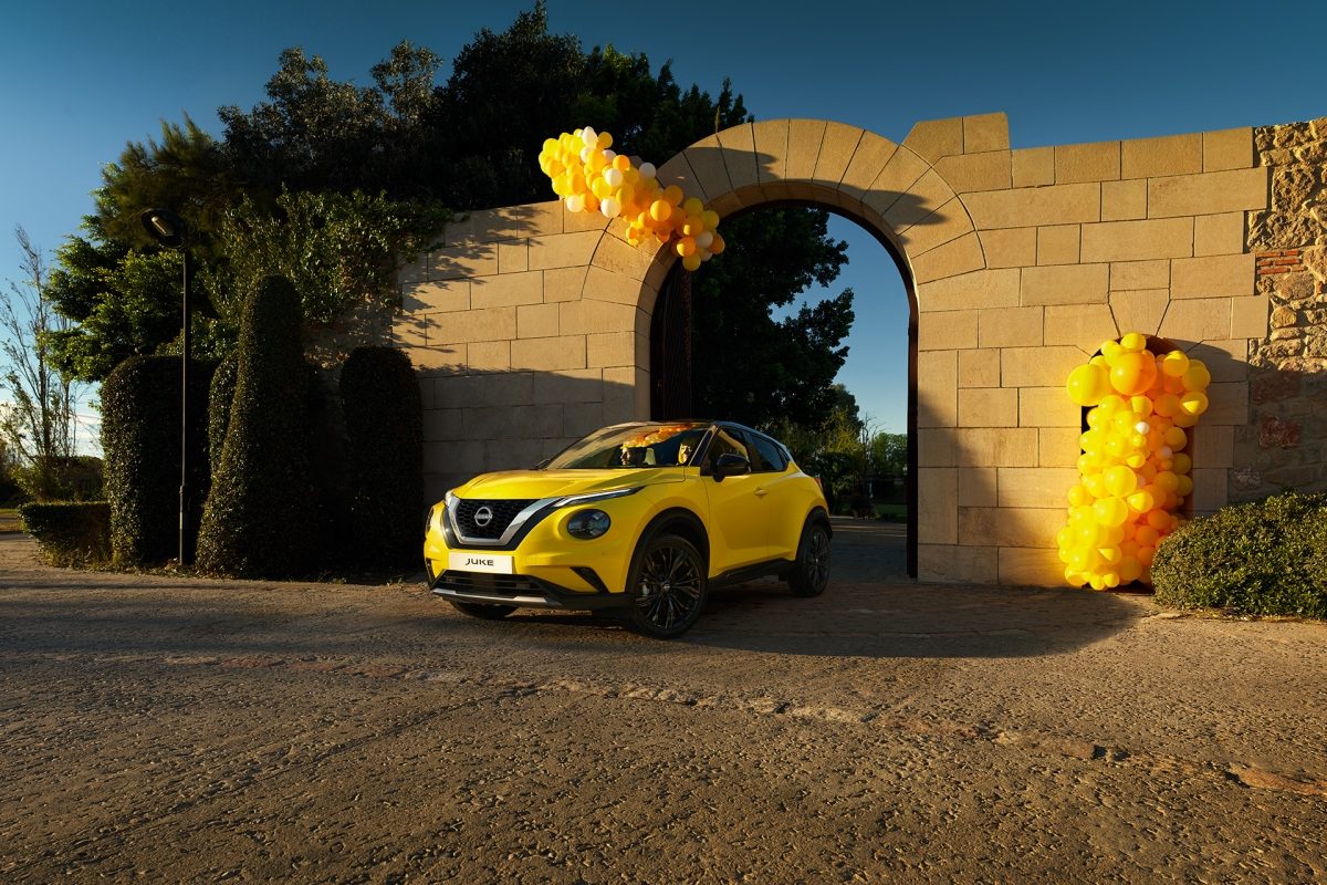Nissan Juke 3/4 front parked view in front of wall with yellow balloons